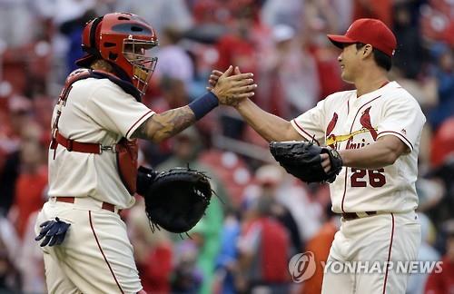 St. Louis Cardinals' relief pitcher Oh Seung-hwan (R) celebrates his first major league save with catcher Yadier Molina against the Milwaukee Brewers in St. Louis in this Associated Press photo on July 2, 2016. (Yonhap)