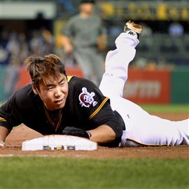 Jung Ho Kang loses his helmet as he gets back to first base safely in the first inning against the Diamondbacks in May 2016.